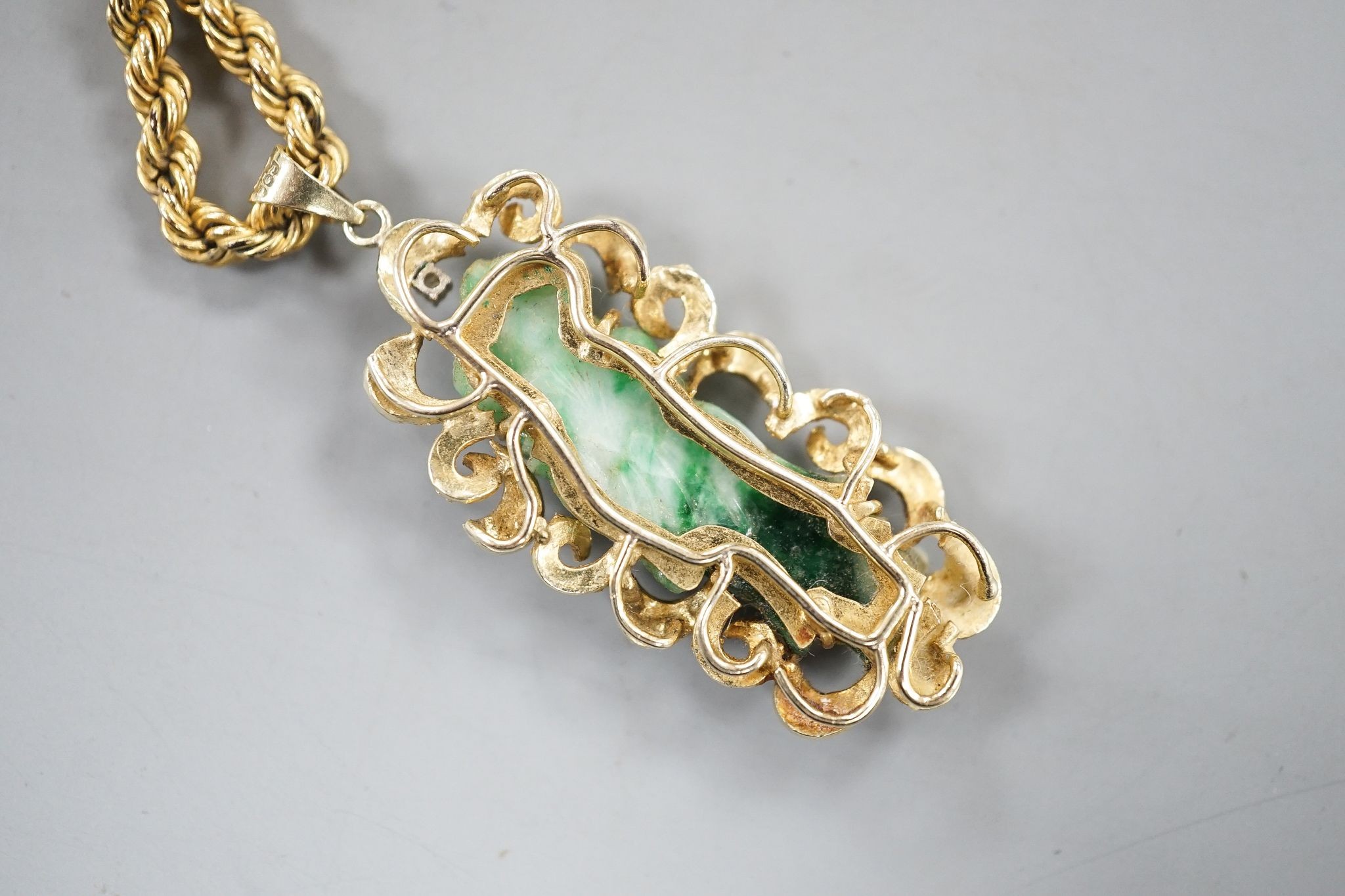 A 14k yellow metal and carved jade set pendant, 45mm, gross 8.5 grams, on a 9ct gold ropetwist chain, 56cm, 10.5 grams and an enamelled gilt white metal pendant.